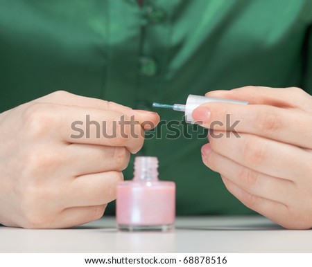 Woman covers nail varnish - close-up of hands