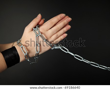 Women\'s hands shackled a metal chain