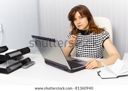 Female secretary working in an office with a laptop
