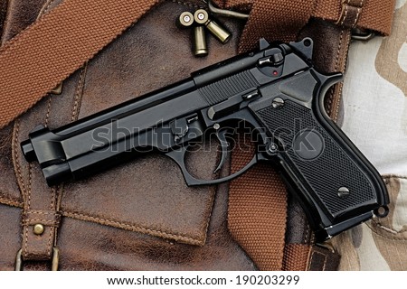 Semi-automatic handgun lying over a Leather handbag, 9mm pistol, Process HDR detail
