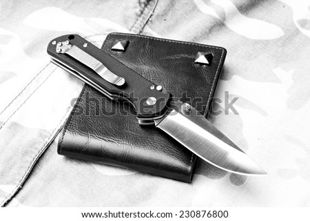 Pocket knife, Black tactical knife on military background. (Black and White)