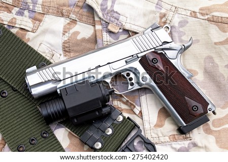 Semi-automatic handgun on camouflage background, Gun on Military texture, .45 pistol.