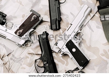 Many Guns on Military texture. Handguns on camouflage background. 9mm, 11mm Pistols. (Process With TV Scan line effect)
