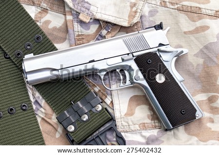 Semi-automatic handgun on camouflage background, Gun on Military texture, .45 pistol.