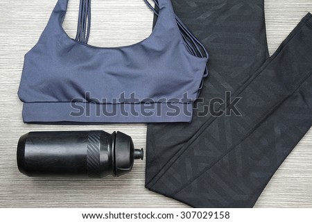 Grey women\'s sports bra and Black Bicycle water bottle. Sport wear, Sport fashion, Sport accessories, Sport equipment.