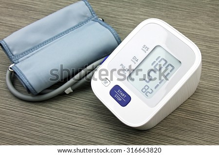 Digital Blood Pressure Monitor on wood background, Medical equipment, Examining equipment.