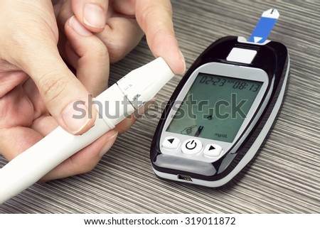 Close-up Of Woman Hands Testing High Blood Sugar With Glucometer, Blood glucose meter, The blood sugar value is measured on a finger, Syringe pen with insulin and glucometer, (Vintage Style Color)