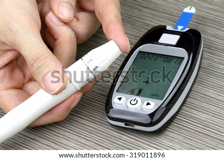 Close-up Of Woman Hands Testing High Blood Sugar With Glucometer, Blood glucose meter, The blood sugar value is measured on a finger, Syringe pen with insulin and glucometer, Blood glucose test.