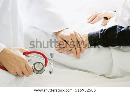 Medical doctor holding patient\'s hands and comforting her with care, Doctor supports her palliative patient with sympathy. (Selective Focus)