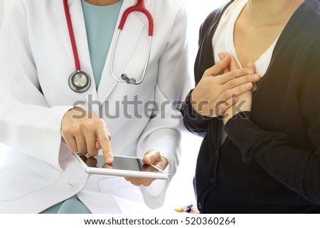 Medical doctor dicusses with patient about the health examination results by using tablet computer, Worried patient with her doctor in medical office, Medical technology concept. (Selective Focus)