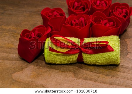 Creative composition with red roses and green towel with red bow