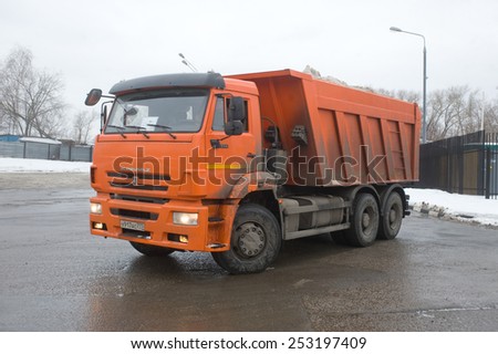 MOSCOW, RUSSIA - February 13, 2015: Orange dump truck KAMAZ on the ground snow melting point, Moscow