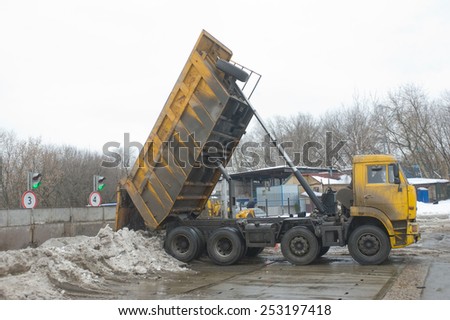 MOSCOW, RUSSIA - February 13, 2015: Unloading dirty snow from the body of the truck KAMAZ in negotable on snow-melting point, Moscow
