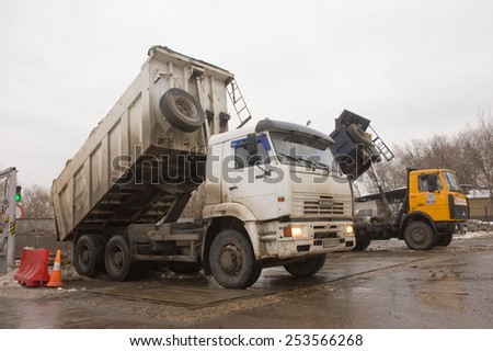 MOSCOW, RUSSIA - February 13, 2015: Unloading dirty snow from the truck body in negotable on snow-melting point, Moscow