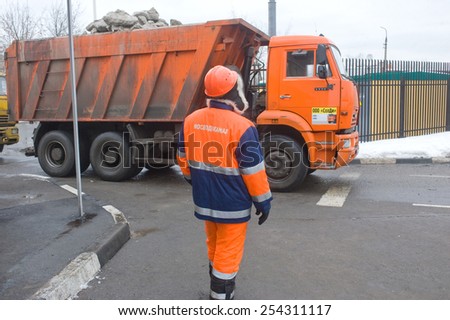 MOSCOW, RUSSIA - February 13, 2015: Employee of Mosvodokanal monitors the entry of a truck working to remove melting snow, Moscow