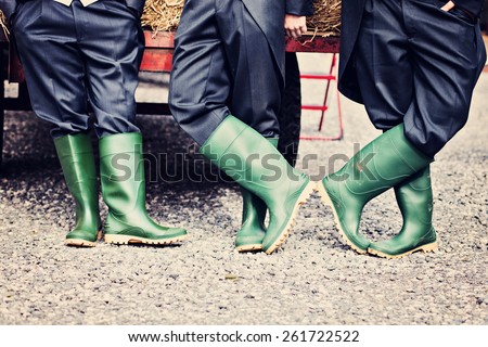 three farmers legs in matching green wellington boots