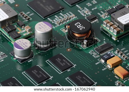 Application Specific Integrated Circuit, inductors, chip capacitors, electrolytic capacitors, Double Data Rate Synchronous Dynamic Random-access chips and resistors mounted on a Printed Wiring Board