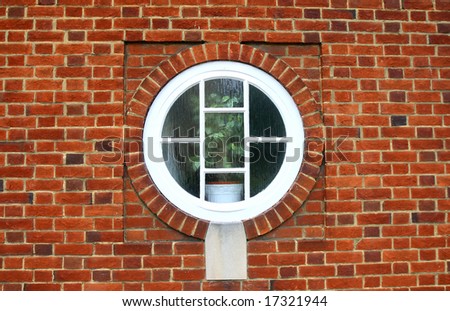 Round white window on red brick wall