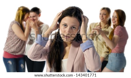A dark haired girl is desperate and holds his hands to his head in the background are out of focus four girls who laugh at them.