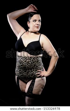 A big woman in black lingerie and leoprint high waist panty looking self-assured in the camera.