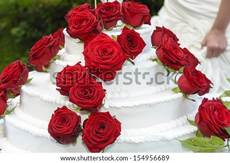 Big white wedding cake with red roses