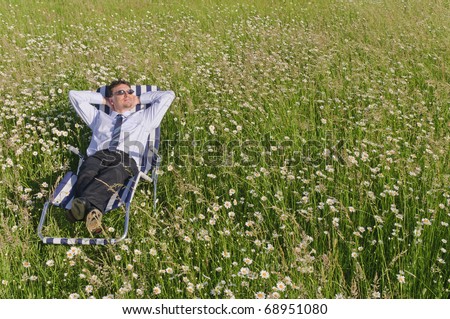 Manager in the Open and is relaxed on a striped deck chair on a lazy meadow