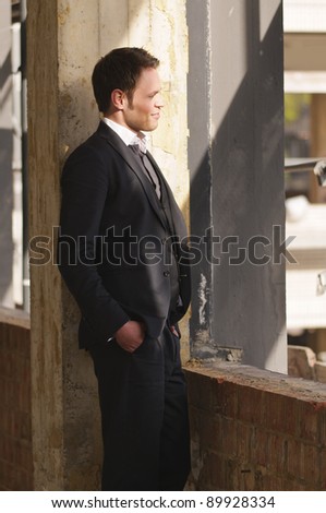 Young man in a dark suit on a construction site.
