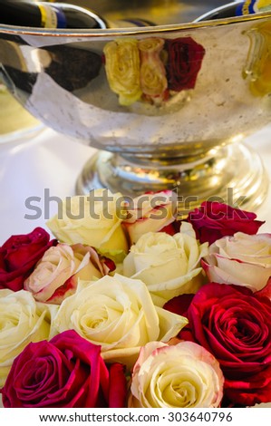 Reflect bridal bouquet with cream-colored roses and red roses in the Champagne Bucket