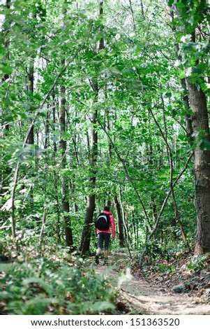 Woman hiking in the woods on a narrow path