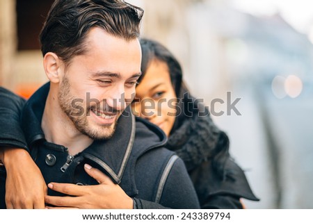 Young interracial couple in love having fun on street