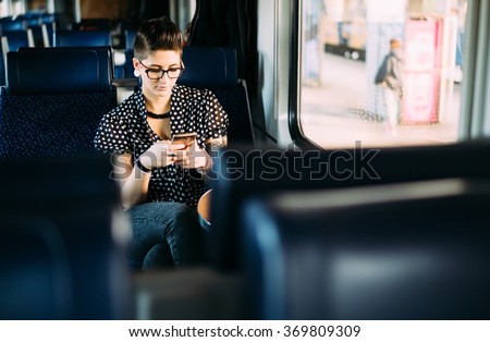 Millenial young woman texting on train