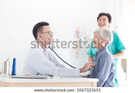 Asian doctor talk with old female patient about disease symptom, elderly health check up , happy hospital