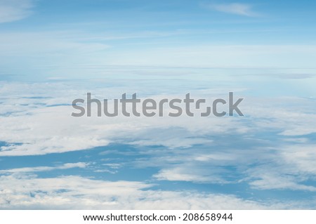 fluffy white clouds and blue sky background seen from airplane