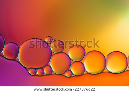 colorful oil bubbles on a water surface abstract background with purple, pink, yellow, green and orange