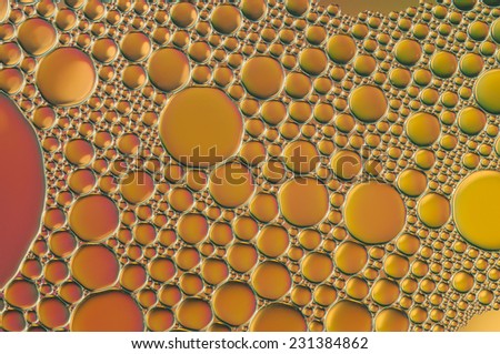 purple and orange oil bubbles on a water surface abstract background