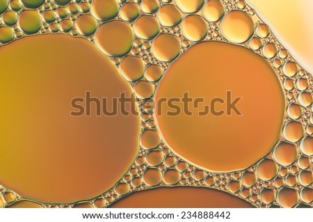 orange oil bubbles on a water surface abstract background