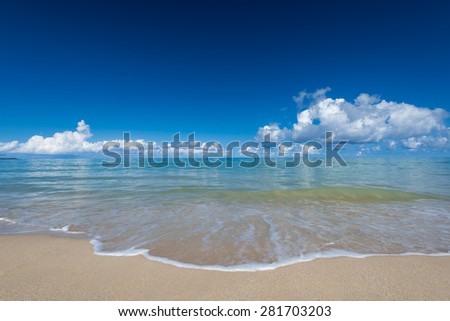 sea waves lash line impact on the sand beach under blue sky, phangnga, thailand