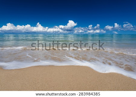 sea waves lash line impact on the sand beach under blue sky, phangnga, thailand