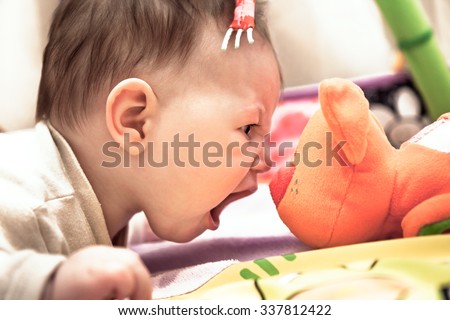 little child crying on toy cat showing his courage and superiority