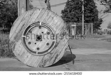 Cable drum in front of electrical post (Black and white)