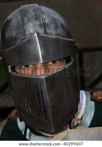 Knight with metal helmet looking at camera