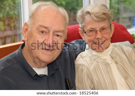 Smiling senior couple on couch in sun room
