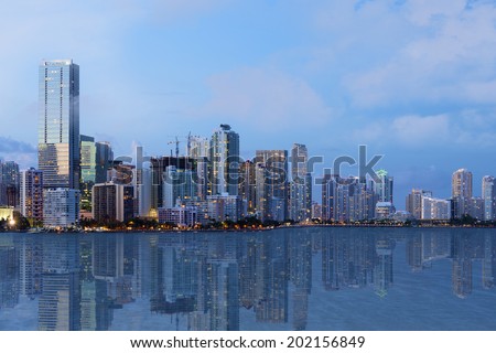 A shot of beautiful Downtown Miami skyline after sunset with reflection in the water. All logos and advertising removed.