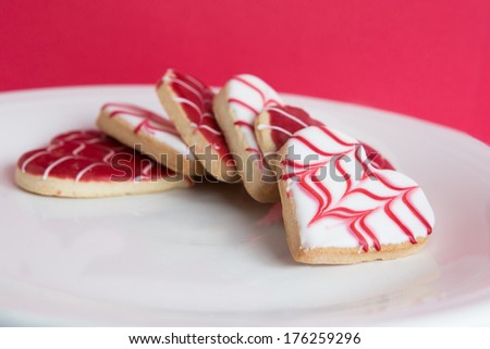 Heart Shaped Cookies on a white plate on a red background