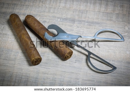 vintage luxe cigar and scissors on a wood table and white brick wall background
