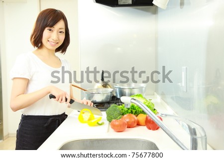 Young Japanese woman cooks in kitchen
