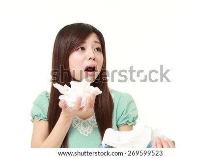 young woman with an allergy sneezing into tissue