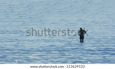 Man contemplating surrounded by water, silhouette of a man in the middle of the sea. Concept for contemplation