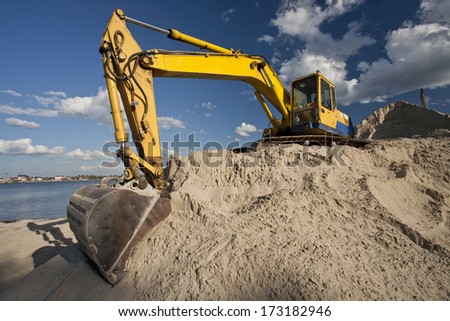 Yellow dredger machine excavating sand