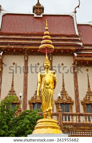 buddhist statue in front of an ordinary thai buddhist temple
